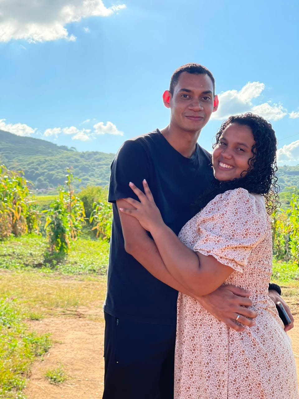 Gustavo e Alícia abraçados ao ar livre, numa roça
